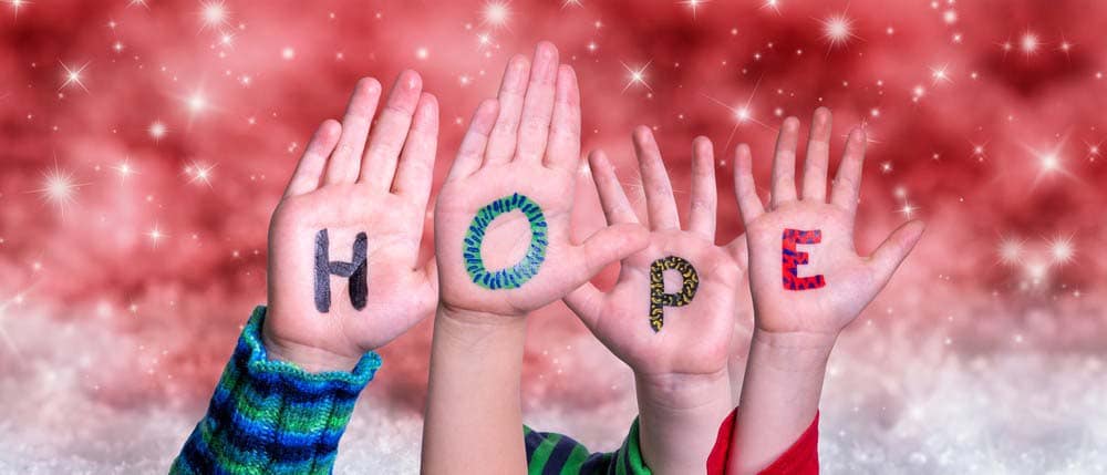 Children's hands showing the word hope.