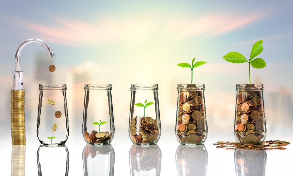 Gold coins and seed in clear bottle on cityscape photo